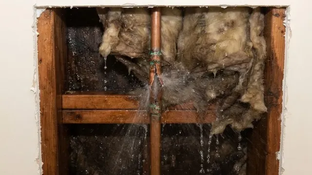 Burst pipe spraying water inside an opened wall cavity