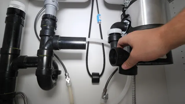 Garbage disposal being serviced under a kitchen sink